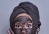 Kobieta w maseczce z węgla aktywnego - to jeden ze sposobów na oczyszczanie twarzy domowym sposobem.