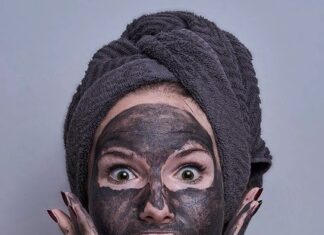 Kobieta w maseczce z węgla aktywnego - to jeden ze sposobów na oczyszczanie twarzy domowym sposobem.